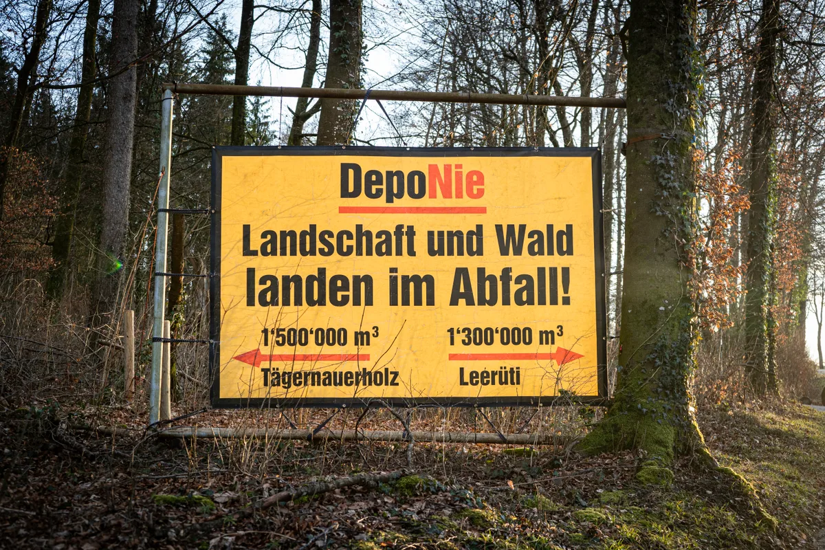 Ein gelbes Protest-Banner steht im Wald.